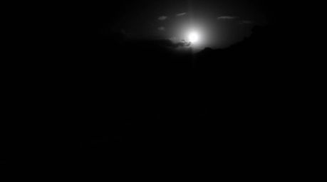 A breathtaking high-angle, black and white photograph captures the intense drama of a sunset over stunning rice terraces nest