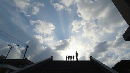 A candid street photograph capturing a high-angle perspective of steps made of light ascending into a cloudy sky, creating a 