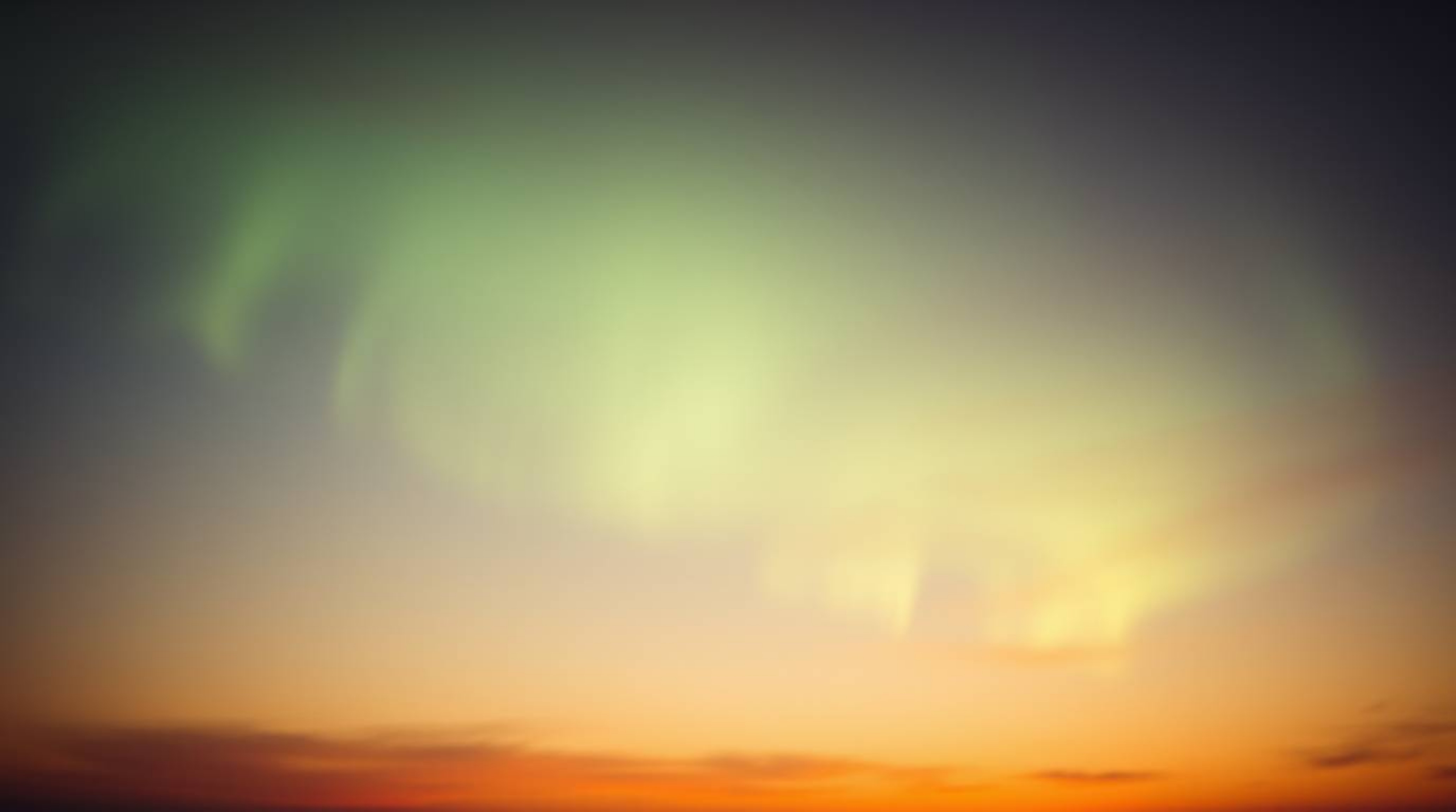 A captivating photograph captures the ethereal beauty of the Northern Lights as they begin to emerge over a breathtaking suns