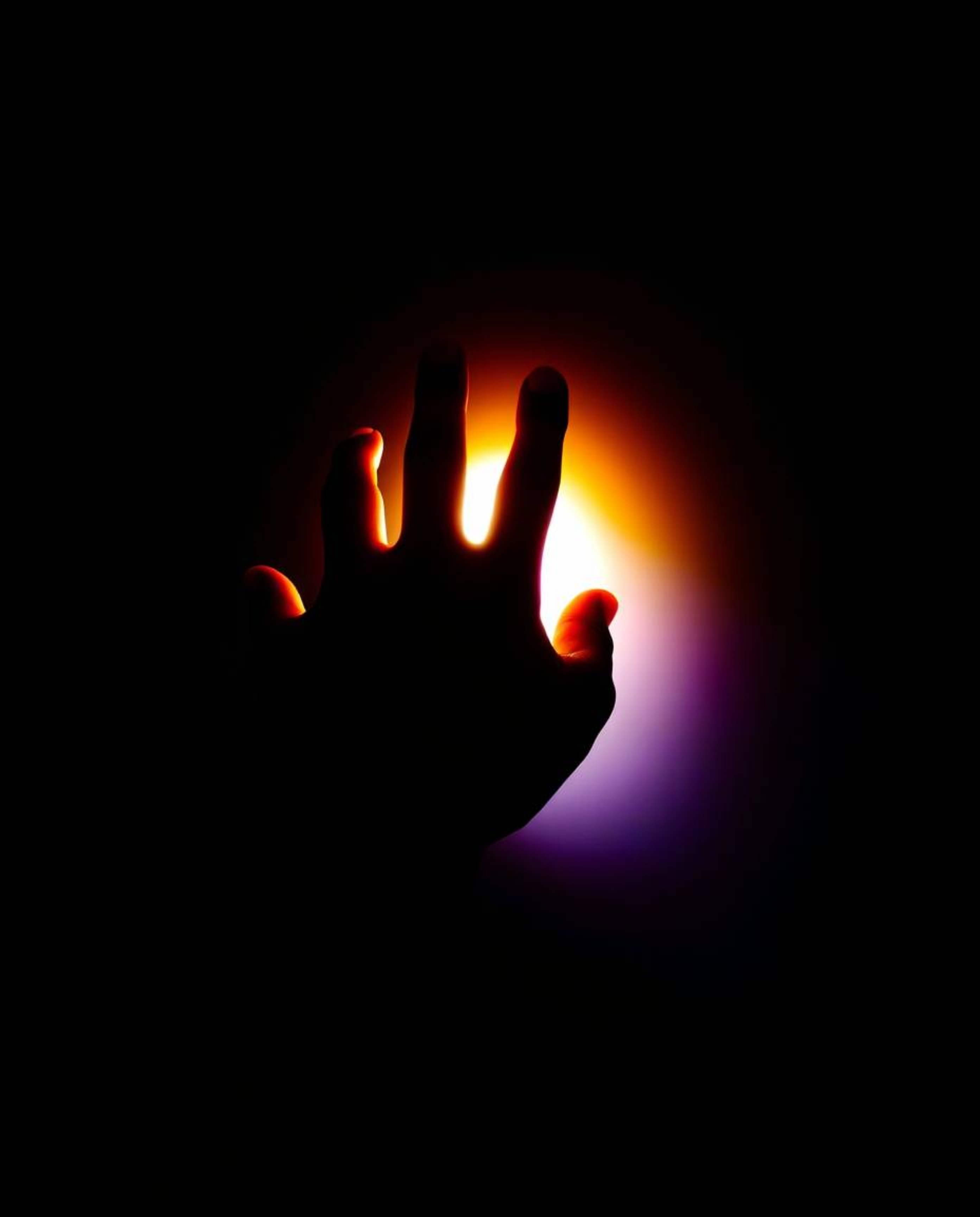 A captivating image showcasing a hand reaching towards a bright light emerging from deep shadow.  The photograph utilizes chi