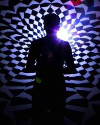 Explore the captivating allure of a silhouetted figure set against a striking black and white geometric pattern, enhanced by 