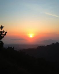 An unusual, original fine art photograph of a Tuscan sunset over misty hills, in the style of Associated Press and editorial 