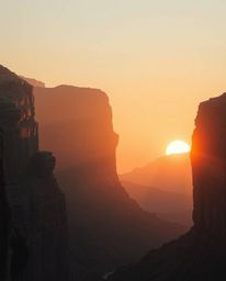 A cinematic and epic scene depicts a sunset illuminating sandstone cliffs in a vast canyon. The image has a heroic scale, whi