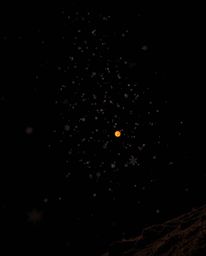 This image captures snowflakes falling during a vibrant sunset from a dramatic low-angle perspective. The scene is set agains