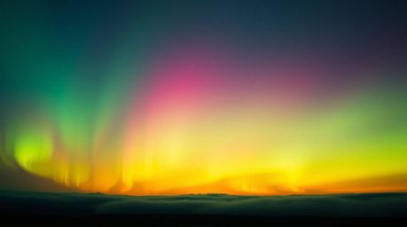 Experience the mesmerizing beauty of bioluminescent colors with the northern lights dancing across a vibrant sunset sky. This