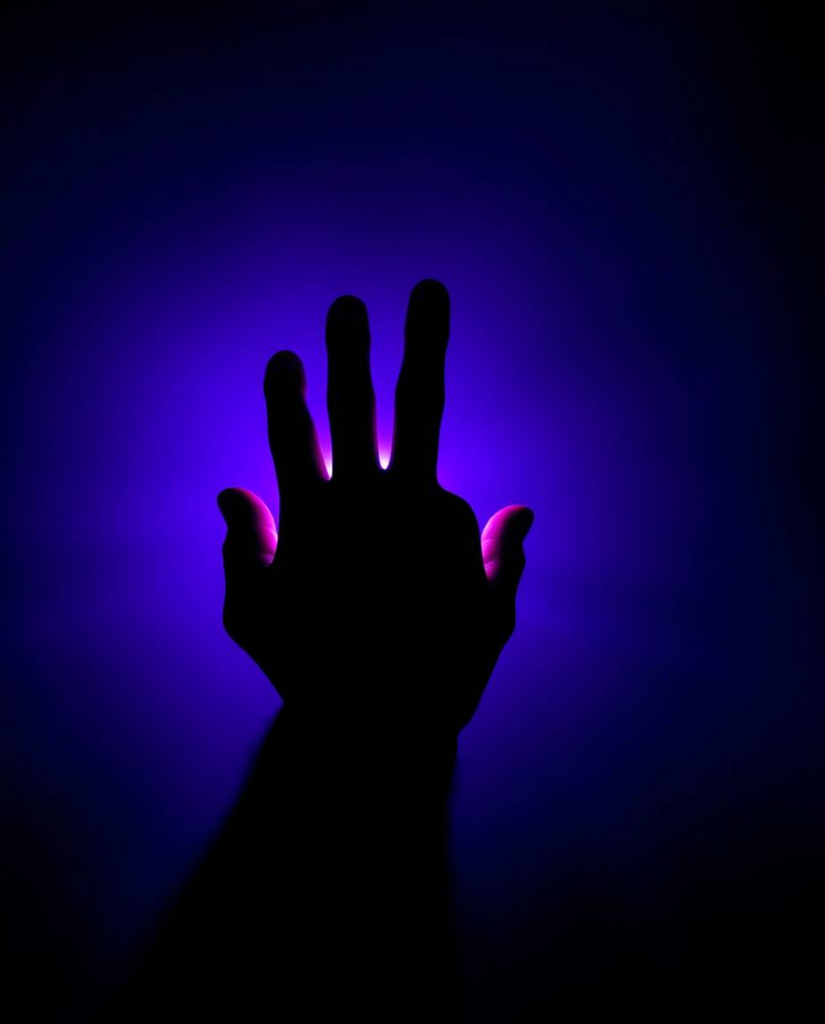 A captivating image featuring a hand reaching from darkness toward a light source, rendered in deep ultraviolet hues and vivi