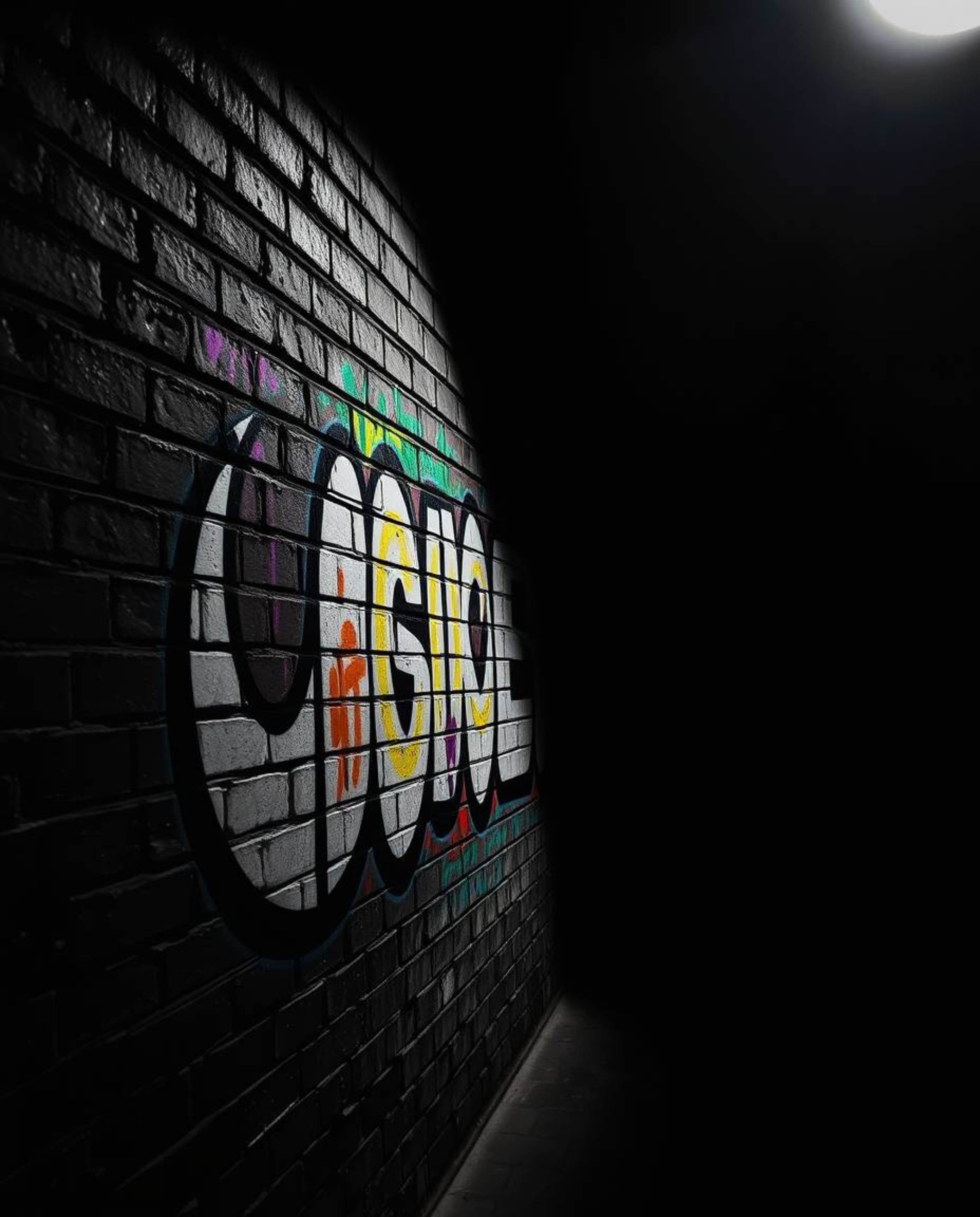 Capture the dynamic energy of vibrant graffiti splashed across a textured brick wall, dramatically lit with chiaroscuro techn