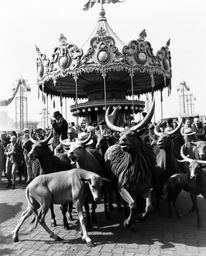 This captivating image presents a classic black and white scene of a carnival, unexpectedly overrun by wild animals. The phot