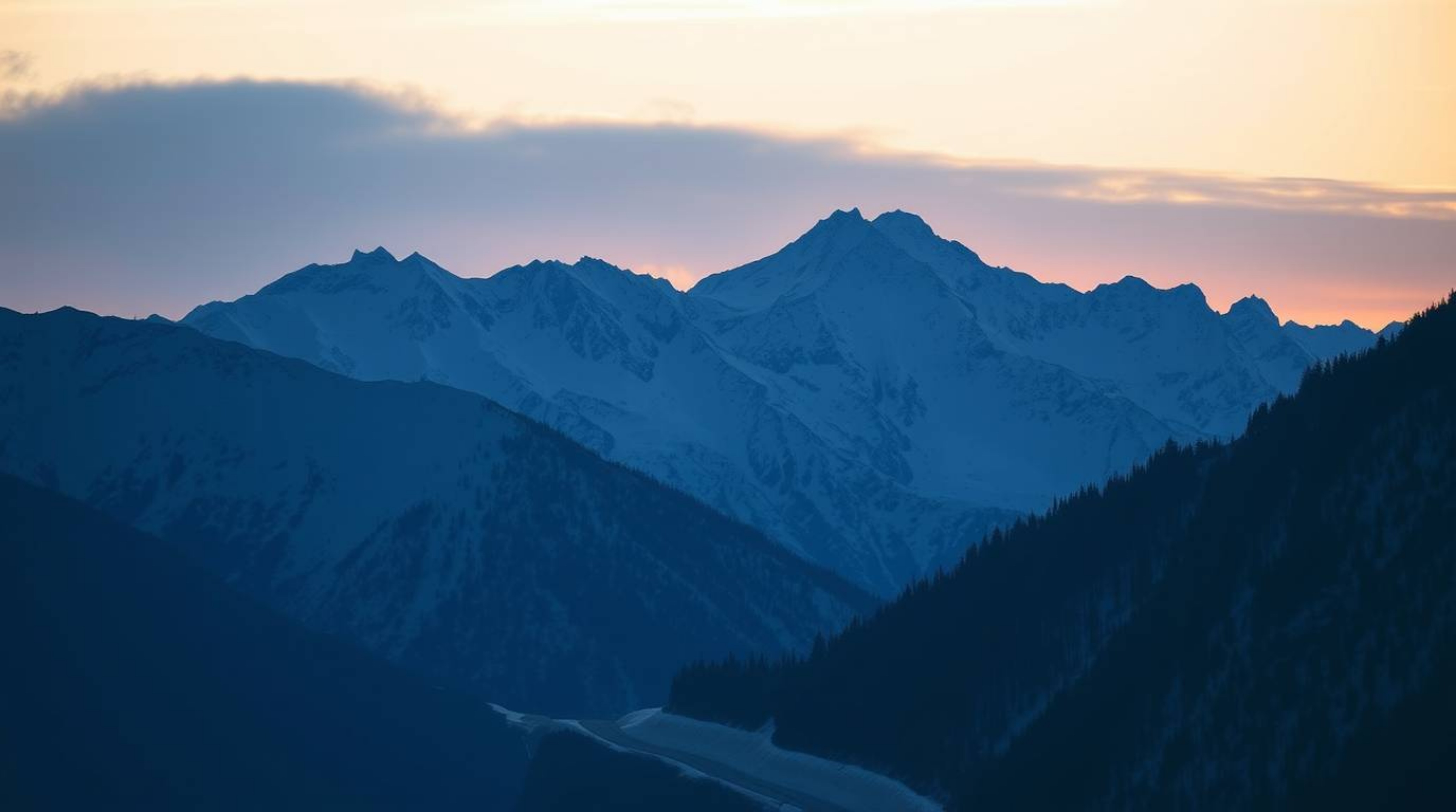 Experience the serene beauty of snow-covered mountains silhouetted against a pastel sunset, bathed in cool blues, greens, and