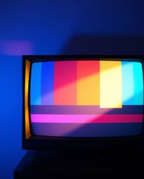 A captivating image of a retro-style TV screen displaying glitch static with vibrant RGB separation.  The scene is softly ill
