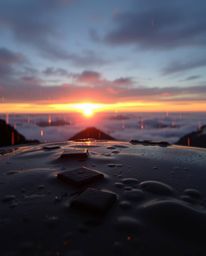 This is an adorable and cute depiction of a wet, rainy scene during sunset from a high alpine peak. The artwork captures driz