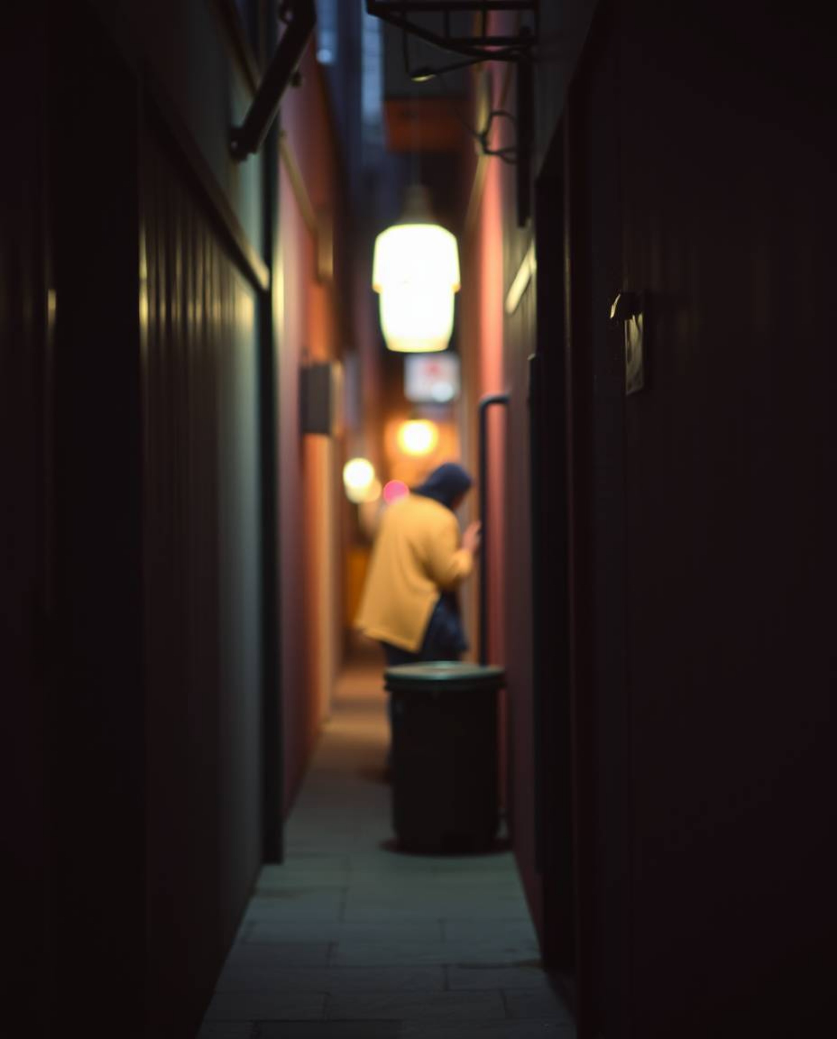 A captivating street photograph showcases eyes peering from the darkness of a shadowy alley at night, rendered in soft pastel