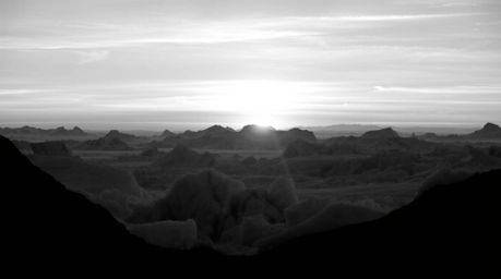 This stunning black and white photograph captures a timeless sunset over the icy polar glaciers, evoking a sense of elegance 