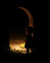 A serene child discovers a mystical portal in their backyard, bathed in ethereal chiaroscuro lighting. The scene evokes a st