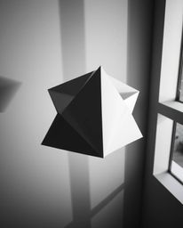 This high-angle, long-exposure monochrome photograph captures a mesmerizing three-dimensional geometric pattern reminiscent o