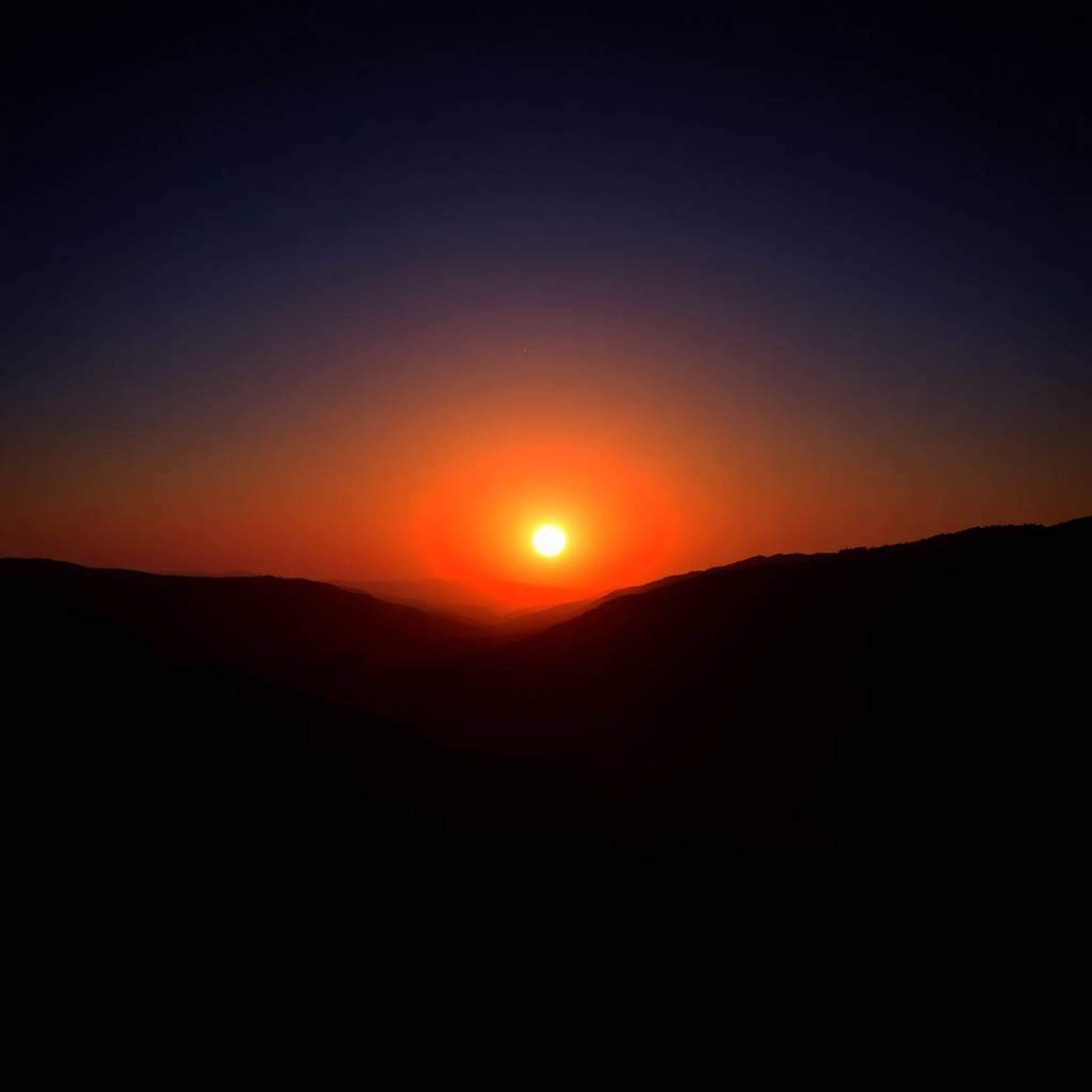 Experience the breathtaking beauty of a fine art photograph capturing a serene sunset over a quiet mountain valley.  This ima