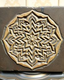 Explore the beauty of Islamic geometric patterns meticulously carved into stone and brought to life on a cast bronze surface.