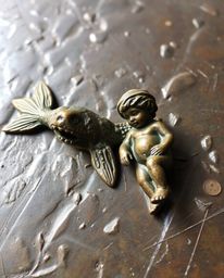This cast bronze sculpture with an antique patina finish depicts a heartwarming scene of a sea creature befriending a human c
