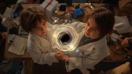 a cinematic, high-contrast photograph of two excited science fair participants, a boy and a girl, likely in their early teens