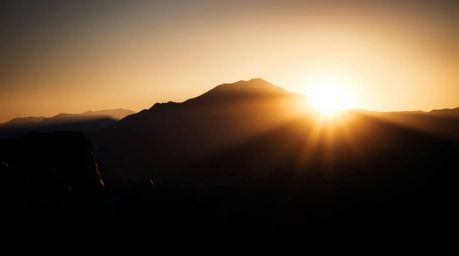 Experience the breathtaking beauty of a volumetrically lit sunset over icy glaciers in the polar region. This high-contrast i