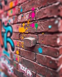 A surreal image showcases a brick wall adorned with vibrant graffiti-style splashes, rendered in captivating infrared tones. 