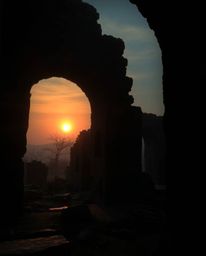An eerie and creepy atmosphere pervades a scene where a sunset casts shadows through ancient stone ruins. This mystic and enc
