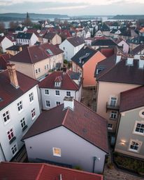 A captivating overhead shot reveals a tranquil town, depicted in a precise architectural photograph or watercolor style. Past