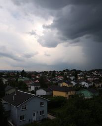 A captivating high-resolution stock photo depicting a sleepy town with pastel-colored houses under dramatic, stormy skies.  T