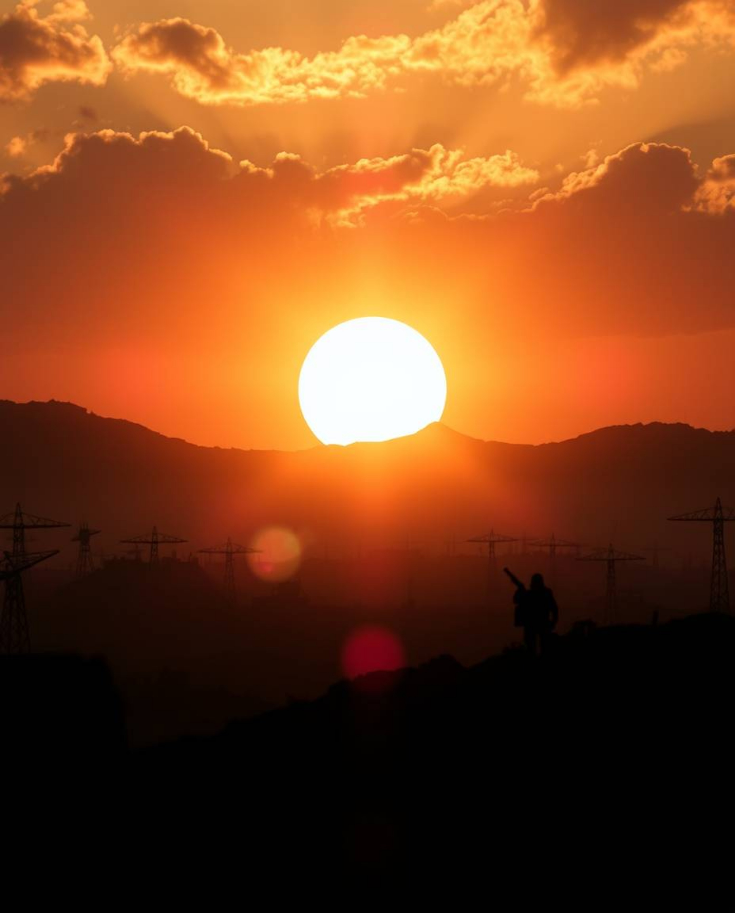 A breathtaking sunrise illuminates a war-torn landscape in a dramatic split-screen composition.  The scene is epic in scale, 