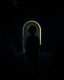 A captivating image depicts a child's silhouetted figure, mysteriously backlit against a glowing portal nestled in their eeri