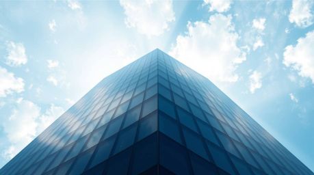 This stunning overhead view logo features a modern glass building seamlessly dissolving into the sky, embodying concepts of a