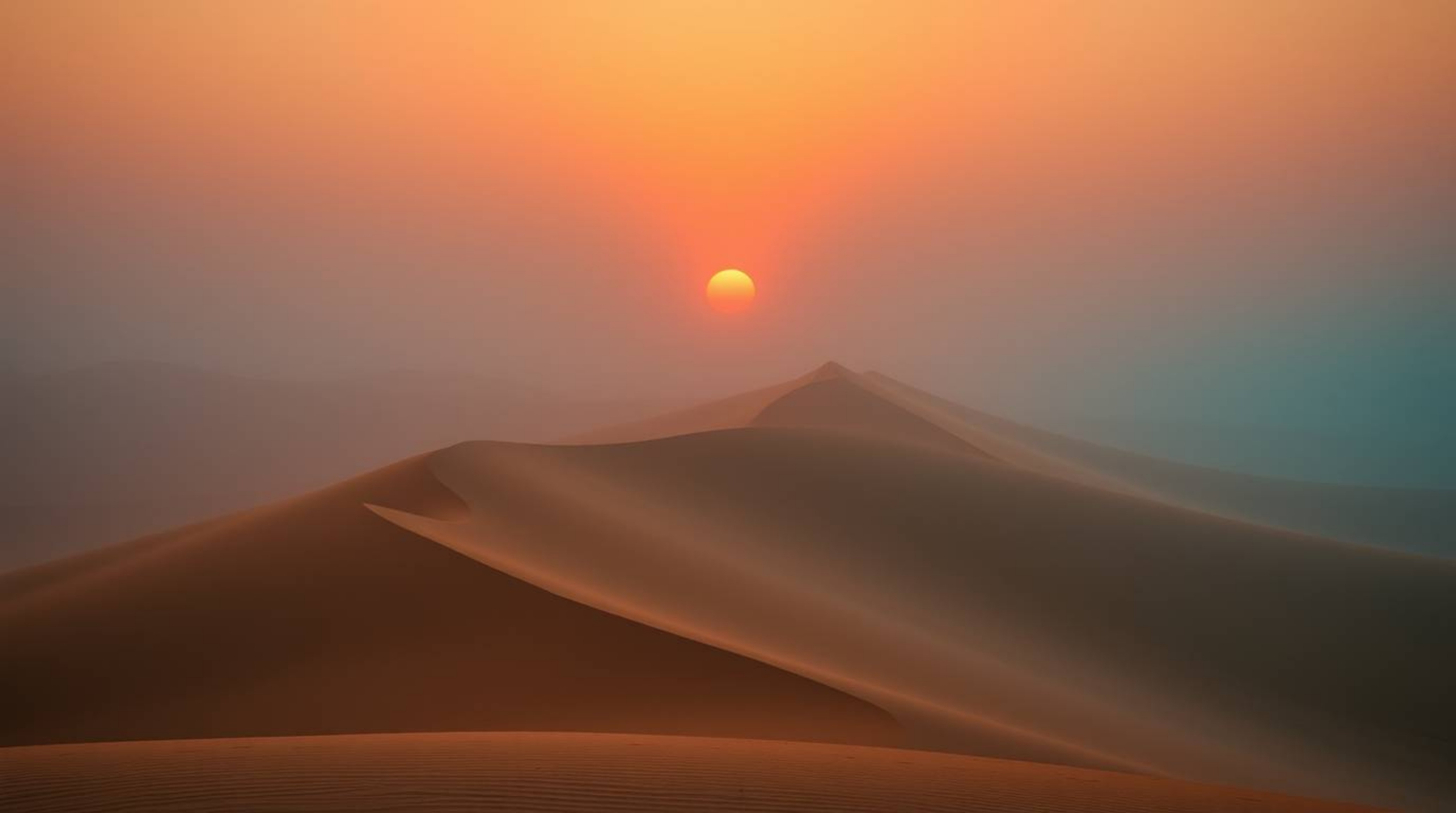 Experience the captivating contrast of a warm terracotta and cool teal sunset over golden desert dunes. This image captures a