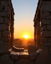 Experience the timeless beauty of ancient stone ruins at sunset, captured in a warm cast bronze sculpture. This piece feature