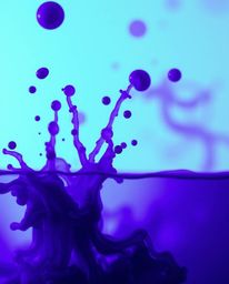 A mesmerizing long-exposure macro photograph showcases vibrant ink splashes in water.  Deep ultraviolet hues create high cont