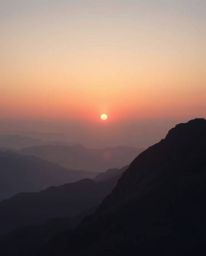 This is a soft cinematic image of a sunset viewed from a high alpine peak, rendered in delicate soft pastel colors to create 