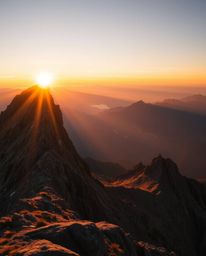 Warm golden hour light bathes a stunning sunset scene viewed from a high alpine peak. This composition is characterized by it