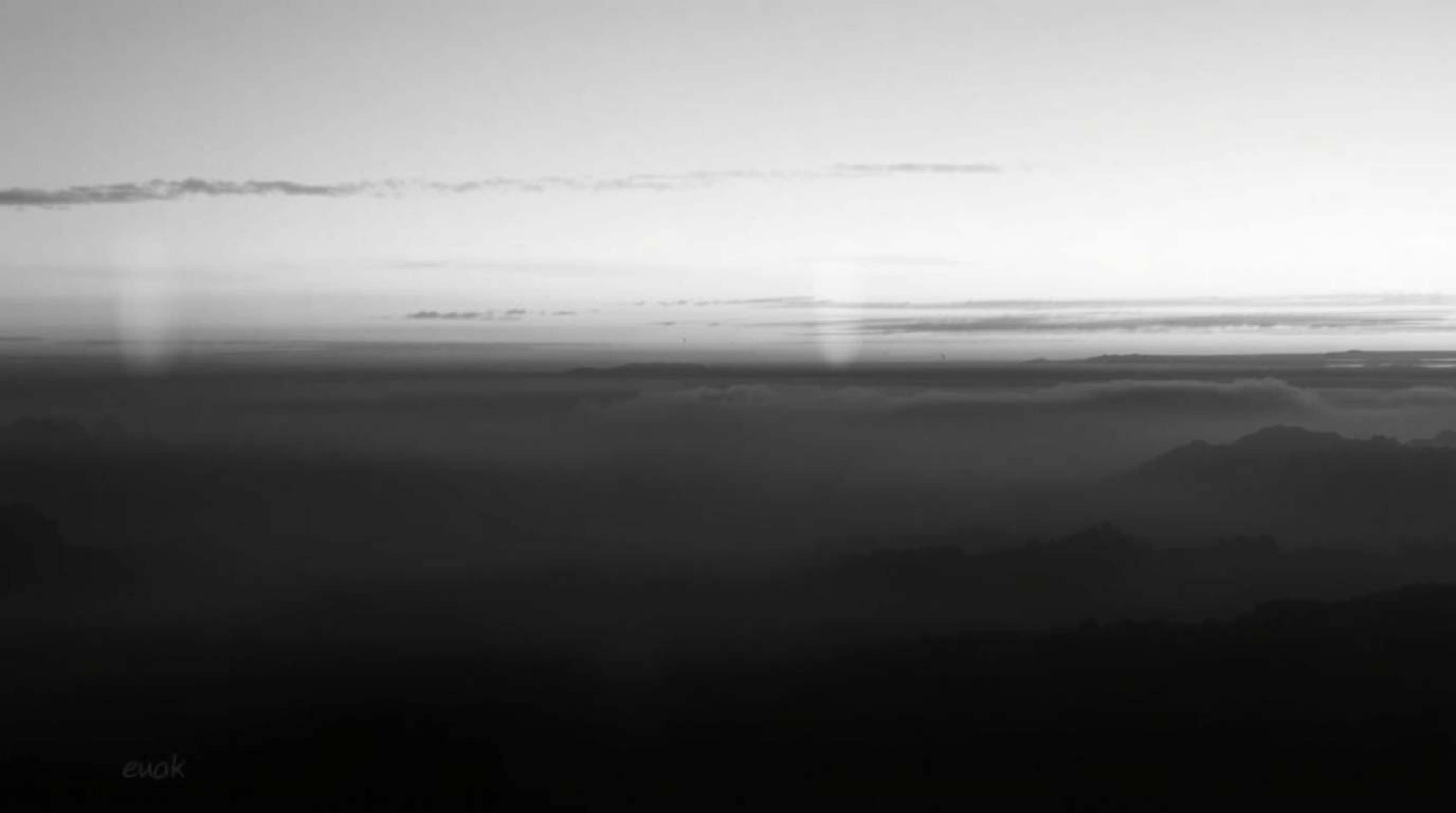 Capture the timeless elegance of a classic black and white photograph featuring the ethereal Northern Lights dancing across a
