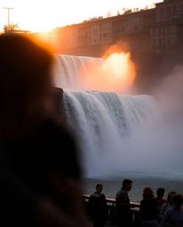This artwork captures the soft, dreamy atmosphere of a sun setting behind a dramatic waterfall through the lens of candid str