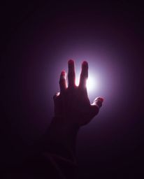 A captivating high-resolution stock photo depicts a hand emerging from darkness, yearning for a source of light.  Rendered in