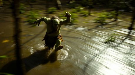 Witness the dynamic motion blur capturing an ogre's energetic dance in a swamp. This scene utilizes high contrast low-key lig
