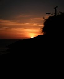 This is a piece of intense, jet-black candid street photography that captures spontaneous urban scenes along a winding coasta