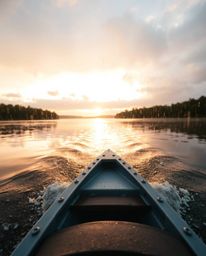 A boat drifts on a lake at sunset, viewed from a low angle perspective in a wet rainy scene, the rain creating reflective sur