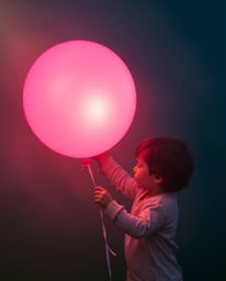 A captivating image of a child holding a balloon, bathed in hazy, soft light and captured with long exposure. This technique 