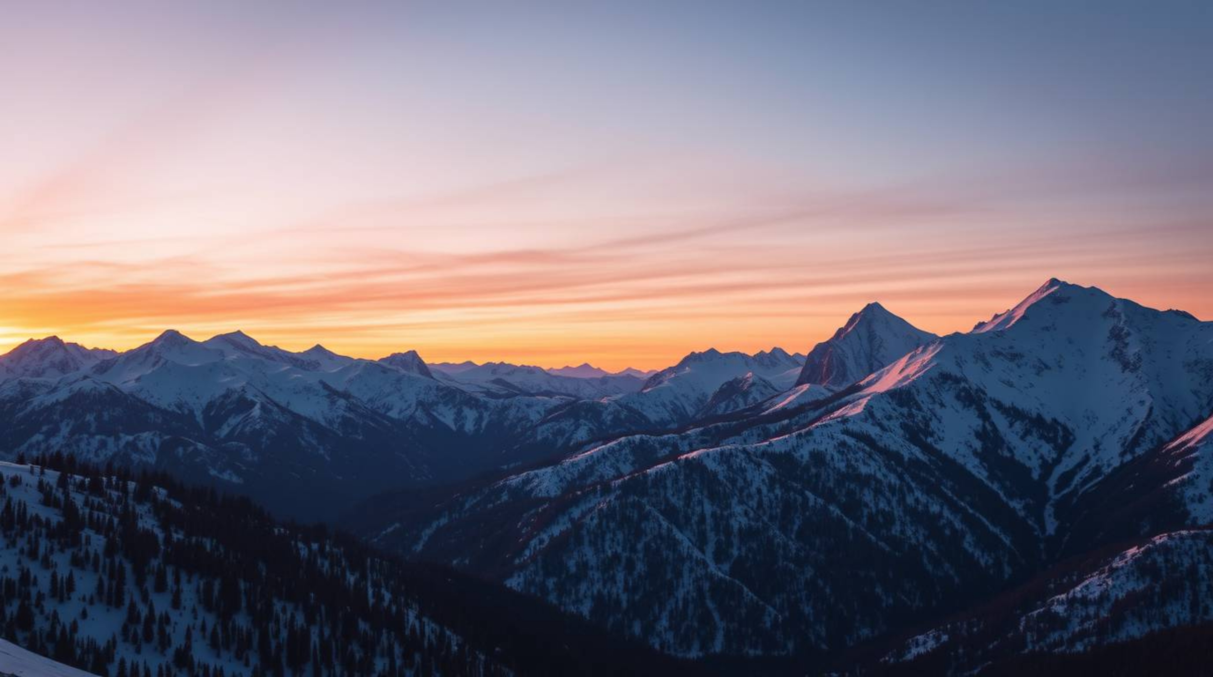 A stunning high-resolution stock photo captures snow-covered mountains bathed in the warm glow of a pastel sunset.  The image