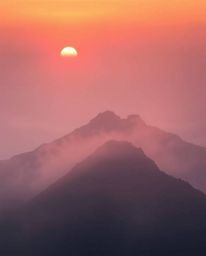 A soft cinematic haze envelops a breathtaking high alpine peak sunset. This composition is defined by its soft focus and a ha