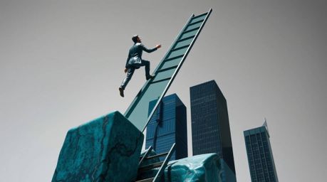 This rich, deep teal bronze sculpture depicts a businessperson ascending a transparent ladder into a sky above skyscrapers.  