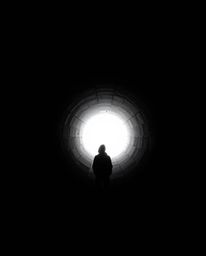 A captivating black and white photograph depicts a person standing at the edge of a tunnel, gazing towards a bright light sou