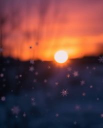 A charming and adorable long-exposure photograph captures the beauty of snowflakes falling during a vibrant sunset. This imag