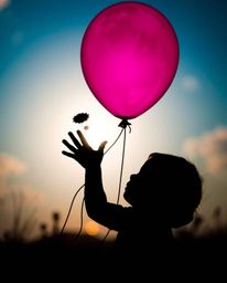 A captivating close-up shot of a child holding a balloon, presented in a silhouetted dreamlike style. The image emphasizes de