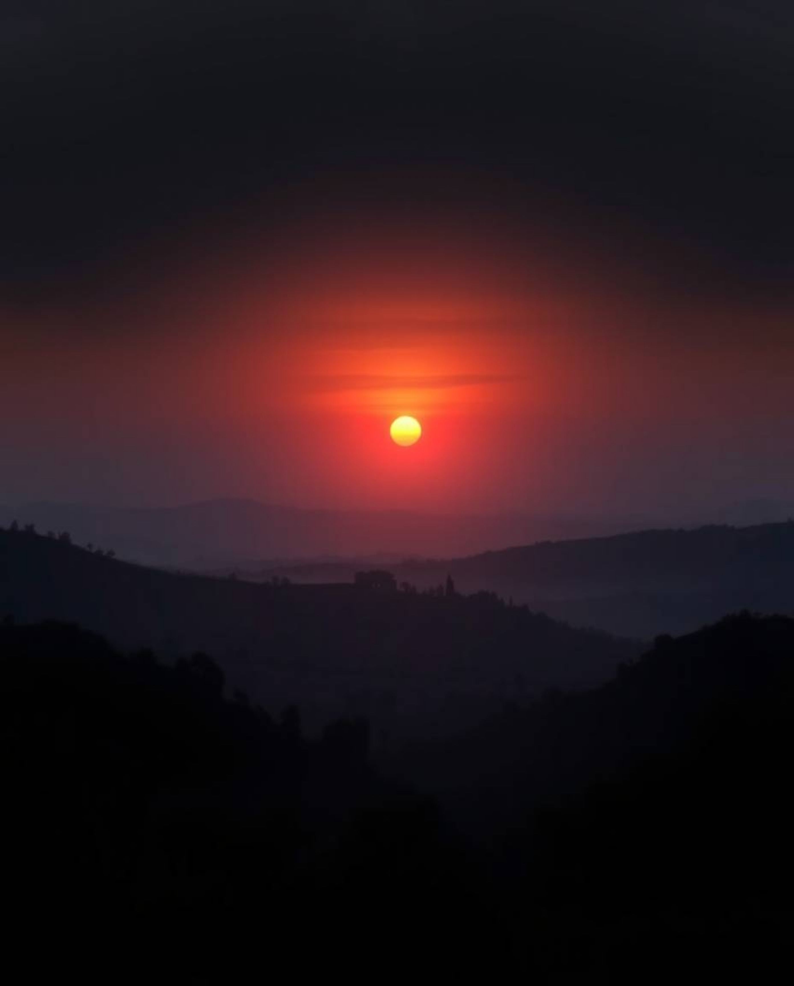 This is a moody digital painting capturing a Tuscan sunset over misty, rolling hills from a high-angle, elevated viewpoint. T
